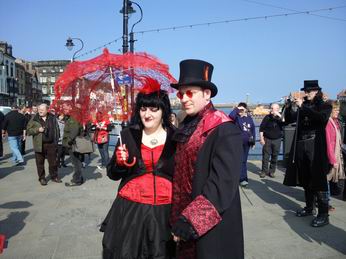Photo of a gothic couple with a red umberella