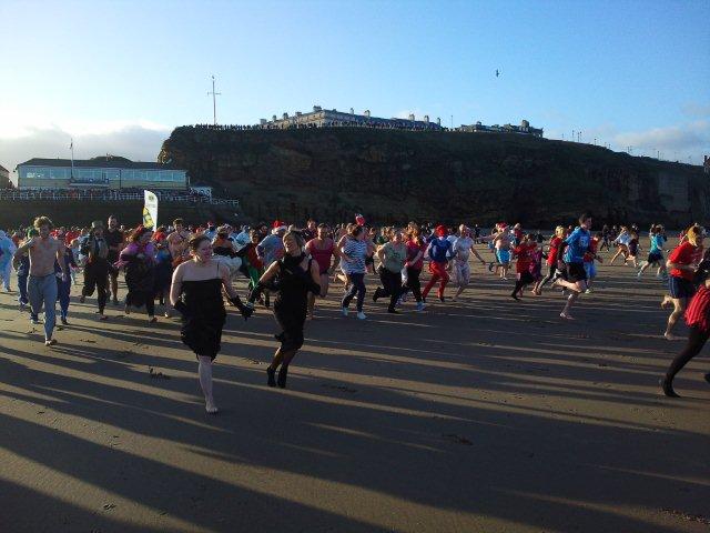 Photo of Boxing Day participants running to the sea