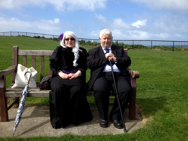 Photo of Gothic couple resting on the cliff top